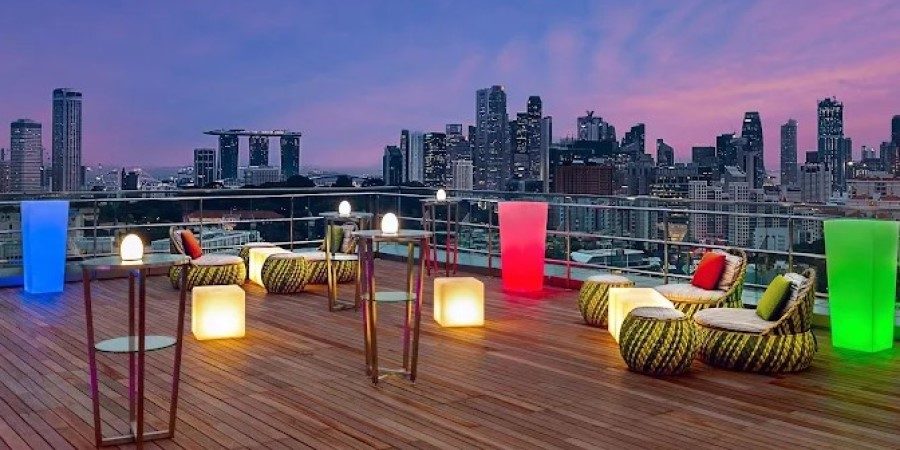 A rooftop deck featuring bright lights and comfortable furniture, perfect for social gatherings under the stars.